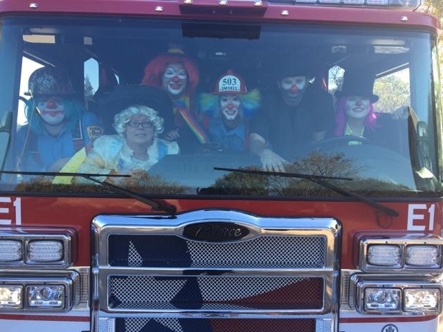Firefighters dressed up as clowns in a fire truck for fire safety programming